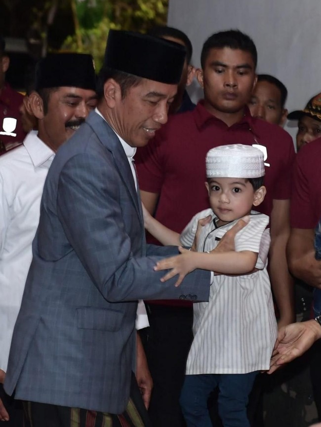 Masih dalam acara Apel Akbar Santri Nusantara, Jan Ethes tampil menggemaskan memakai baju koko dipadu celana. Putra dari Gibran Rakabuming dan Selvi Andanda itu juga masih memakai peci putih, sambil digandeng Sang Eyang. Foto: Kris - Biro Pers Setpres
