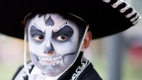 Orang dewasa hingga anak-anak tak ingin ketinggalan ikut serta dalam perayaan menghormati orang mati tersebut. Andres Stapff/Reuters.