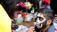 Seorang pria tengah dihias untuk ikut serta dalam perayaan Day of The Dead. Andres Stapff/Reuters.
