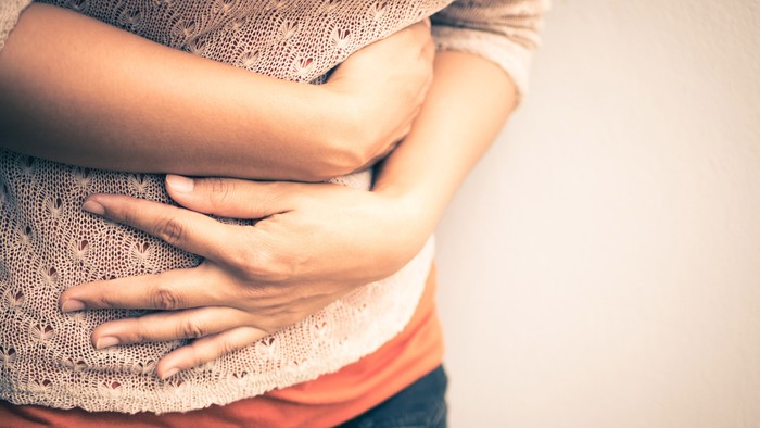 Young beautiful woman having painful stomachache.Chronic gastritis. Abdomen bloating concept.