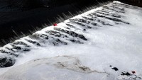 Tampak sejumlah sampah ikut hanyut diantara air yang berbusa di Sungai Kanal Banjir Timur.