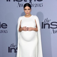 Gaun putih dengan cape menjadi salah satu penampilan terbaik Kim. Foto: Getty Images