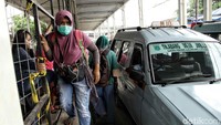 Angkot tampak berhenti di depan celah fondasi Skybridge untuk menarik penumpang.
