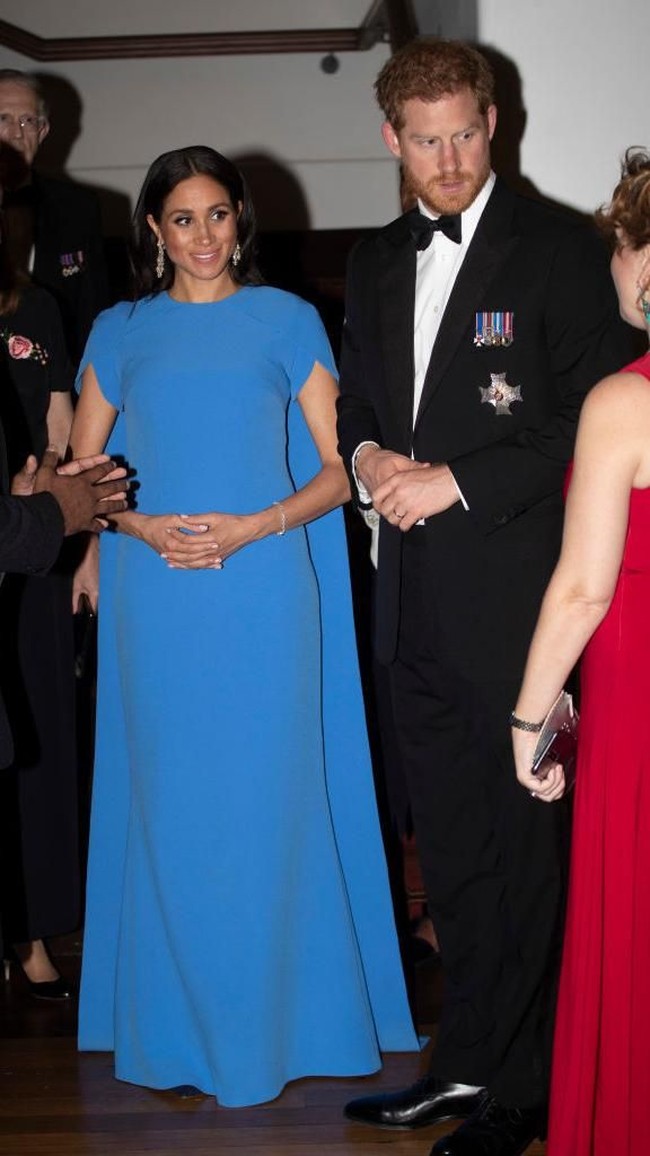 Bak superhero, Meghan tampil dalam balutan gaun biru bersayap rancangan Daniela Karnuts dari label Safiyaa saat menghadiri jamuan malam resmi di Fiji. (Foto: Getty Images)