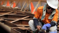 Tampak seorang pekerja tengah mengerjakan konstruksi JPO.