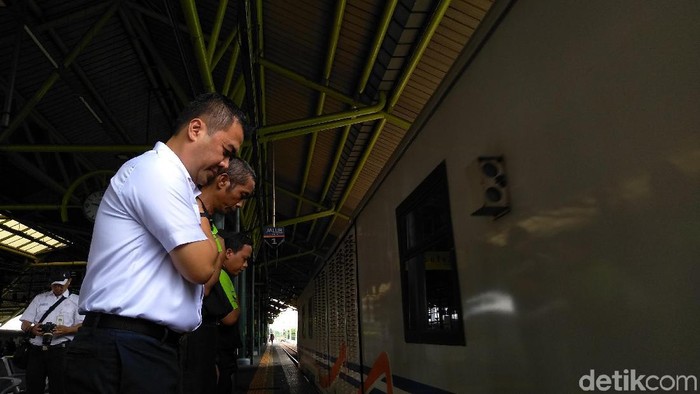 Porter dan pegawai PT KAI menunduk saat kereta berangkat