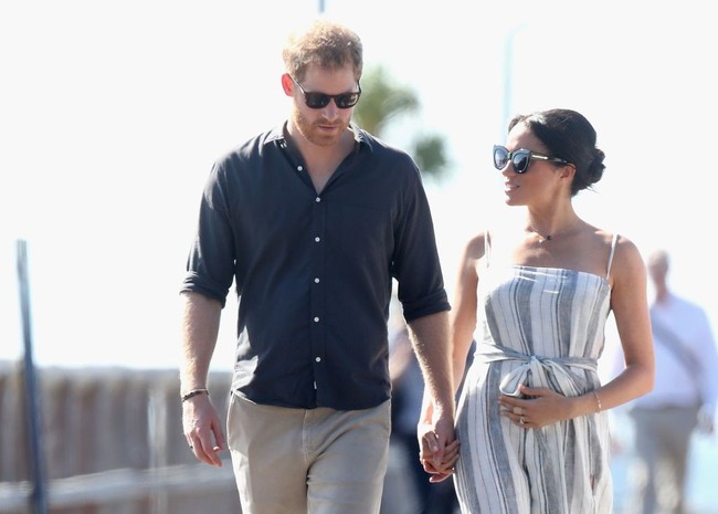 Berjalan bersama Pangeran Harry di dermaga teluk Kingfisher, Senin (22/10/2018), Meghan Markle tampak beberapa kali kedapatan memegangi perutnya yang mulai membuncit. Foto: Getty Images