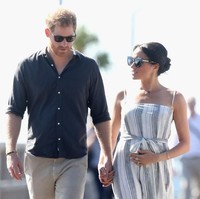 Berjalan bersama Pangeran Harry di dermaga teluk Kingfisher, Senin (22/10/2018), Meghan Markle tampak beberapa kali kedapatan memegangi perutnya yang mulai membuncit. Foto: Getty Images