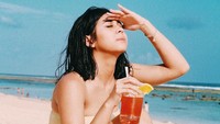 Teriknya sinar matahari di pantai tak menyurutkan semangat Kesha. Sambil santai, ia menikmati segelas minuman dingin. Tampaknya Kesha baru saja habis berenang karena rambutnya terlihat basah.  Foto: Instagram Kesha Ratuliu