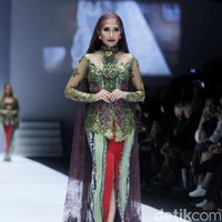 Penampilan dramatis diberikan oleh Puteri Indonesia 2004 Artika Sari Devi. Berjalan dengan wajah fierce, Artika terlihat memakai kebaya hijau dengan veil panjang berwarna ungu saat menjadi model Anne Avantie di Jakarta Fashion Week 2019. Foto: Mohammad Abduh/Wolipop