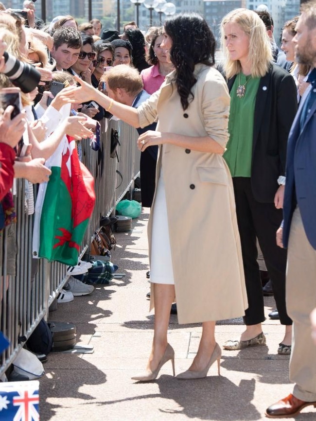 Meski berstatus pengawal bersenjata, sang bodyguard tetap bersolek dalam balutan busana feminin. Saat mengawal Meghan di Sydney, perempuan berambut pirang itu tampil smart chic dengan blus hijau yang dibungkus blazer hitam serta sepatu flat bermotif kulit ular. (Foto: Getty Images)