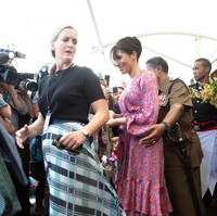 Inilah sosok bodyguard perempuan (kiri berbaju hitam) yang namanya dirahasiakan tersebut saat ditugaskan dalam tur perdana Pangeran Harry dan Meghan Markle ke Australia dan sekitarnya. Foto ini diambil ketika Meghan berkunjung ke sebuah pasar tradisional di Suva, Fiji, Rabu (24/10/2018). (Foto: Getty Images)