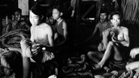 Sejumlah pemuda bekerja di sebuah pabrik tekstil pada tahun 1955. Three Lions/Getty Images.