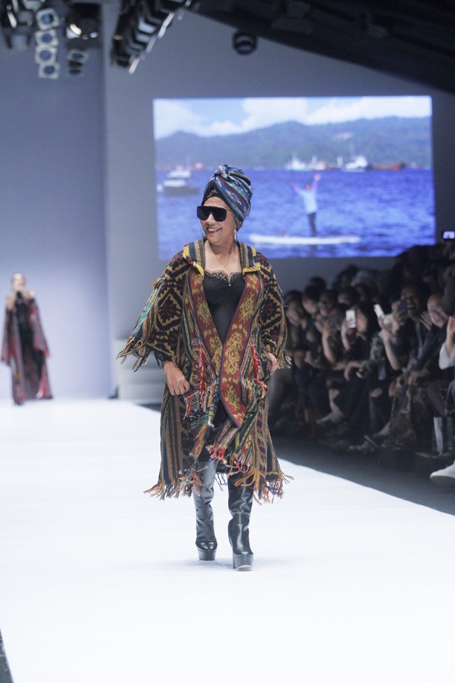 Sang menteri tampil dengan bustier hitam seksi yang dibalut jaket kain tenun dalam warna tanah. Paduan bersama sepatu boot tinggi berbahan glossy makin menegaskan keunikan gaya Susi. Foto: Dok. Moh. Abduh/Wolipop