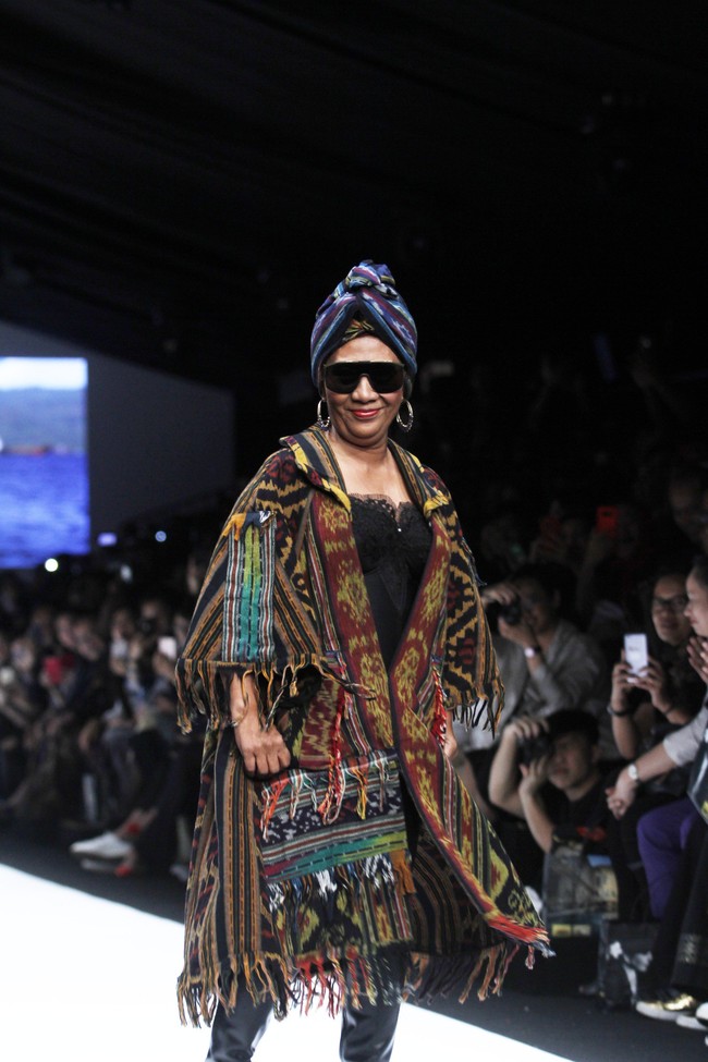 Tampil luwes saat berjalan di catwalk, Menteri Kelautan dan Perikanan Susi Pudjiastuti membuat kehebohan ketika tampil sebagai model fashion show Anne Avantie di Jakarta Fashion Week 2019. Susi hadir dibalut bustier hitam dan kain tenun sebagai outer cape dan bawahan. Penampilan Susi makin dramatis dengan boots, turban dan kacamata hitamnya. Foto: Mohammad Abduh/Wolipop