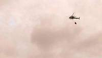 Sebuah helikopter tampak menerjunkan bom air di sejumlah titik api untuk memadamkan kebakaran di hutan Banos de Agua. Jackson Zamora/via Reuters.
