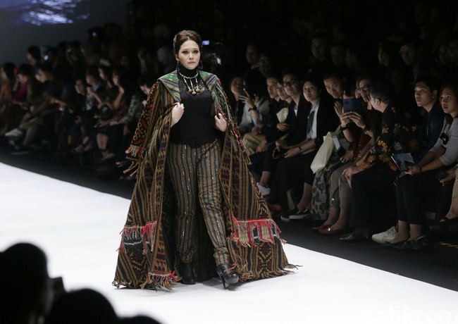 Maia yang merupakan ibu dari tiga putra Ahmad Dhani, Al, El dan Dul itu berjalan di catwalk memakai cape tenun berdetail fringe. Dia mengenakan celana tenun yang semotif dengan capenya. Foto: Palevi S/detikFoto