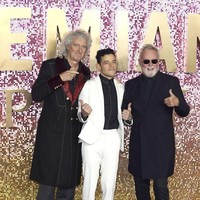Rami Malek berpose bersama dua personel Queen, gitaris Brian May dan drummer Roger Taylor, saat menghadiri premier film Bohemian Rhapsody di London, Inggris, Rabu (25/10/2018). Rami menebar pesonanya dalam balutan setelan bernuansa monokrom. (Foto: Getty Images)
