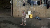 Tak hanya orang dewasa. Ibu-ibu dan anak-anak juga terlihat di pinggir Kali Ciliwung tersebut.
