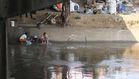 Beberapa anak juga nampak bermain di bantaran Kali Ciliwung ini.