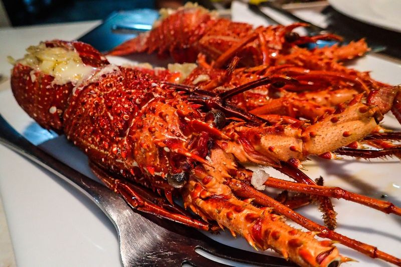 Grilled lobster on the shell sitting on a banana leaf.