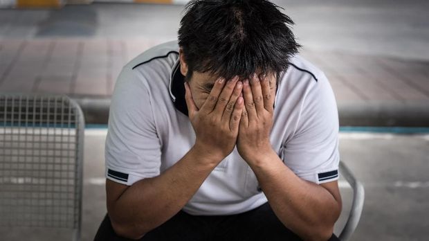 Strees, stres, ilustrasi, pensiun, murung, sedih Man fired from job sitting hold the head with hand and worried stressed face expression outside office