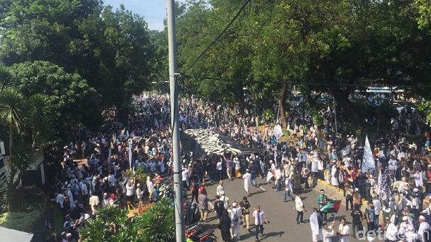 Massa Bentangkan Bendera Berkalimat Tauhid Raksasa di Medan Merdeka