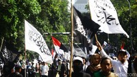 Massa bergeser sambil meneriakkan kalimat tauhid.