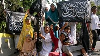 Sejumlah anak-anak pun tampak ikut serta mengibarkan bendera bertuliskan kalimat tauhid berukuran besar.