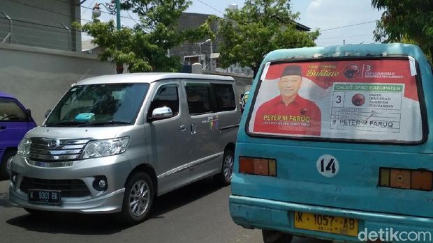 Salah satu mobil angkutan umum yang ditempeli foto caleg di Kudus. 