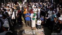 Sejumlah orang tengah melaksanakan Salat ditengah keramaian aksi bela tauhid di Jakarta.