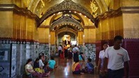 Jemaah akan membeli daun emas seharga 2.000 kyat setara Rp 20 ribu untuk lima lembarnya di kios-kios sekitar kuil. Mereka berbaris untuk menempelkannya pada Buddha besar sebagai persembahan dan para traveler pun bisa menyaksikannya (Vivien Cumming/BBC Travel)