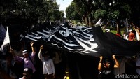 Setelah dibentangkan di kawasan Patung Kuda Monas, bendera itu diarak oleh massa menuju depan Kemenko Polhukam. Teriakan takbir dan kalimat laillah hailalah terdengar ketika bendera itu diarak menuju Kemenko Polhukam.