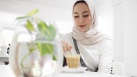 Melky resmi mempersunting Dewi pada 2012 lalu. Wanita berhijab ini ternyata juga suka ngopi. Lihat pose manisnya saat mengaduk segelas kopi. Foto: instagram @dewi_melky