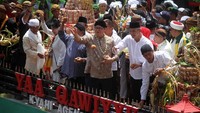 Menteri Perindustrian Airlangga Hartarto bersama Gubernur Jawa Tengah, Ganjar Pranowo, menyebar apem saat menghadiri perayaan haul Kiai Ageng Gribig di Klaten, Jawa Tengah, Jumat (26/10). Pool/Kemenperin.