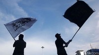 Massa mengibarkan bendera tauhid.