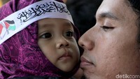 Seorang balita digendong ayahnya mengikuti acara aksi bela tauhid.