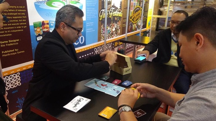 Joshua Mulia Simandjuntak mencoba game Coffeetopia di booth Indonesia, SPIEL 18, Essen. Foto: Istimewa Joshua Mulia Simandjuntak mencoba game Coffeetopia di booth Indonesia, SPIEL 18, Essen. Foto: Istimewa