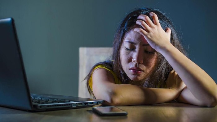 ilustrasi cyberbully dramatic portrait scared and stressed Asian Korean teen girl or young woman with laptop computer and mobile phone suffering cyber bullying stalked and harassed with internet password hacked