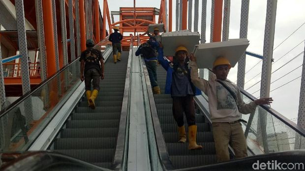 Petugas membersihkan plafon stasiun LRT Palembang yang ambrol