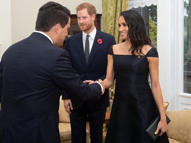Meghan Markle lalu menyempurnakan gayanya dengan sandal heels minimalis dan clutch berwarna senada. Rambut panjangnya yang bergelombang dibiarkan tergerai bebas dan wajahnya dipulas minimalis sehingga meninggalkan kesan kecantikan yang alami. (Foto: Getty Images)