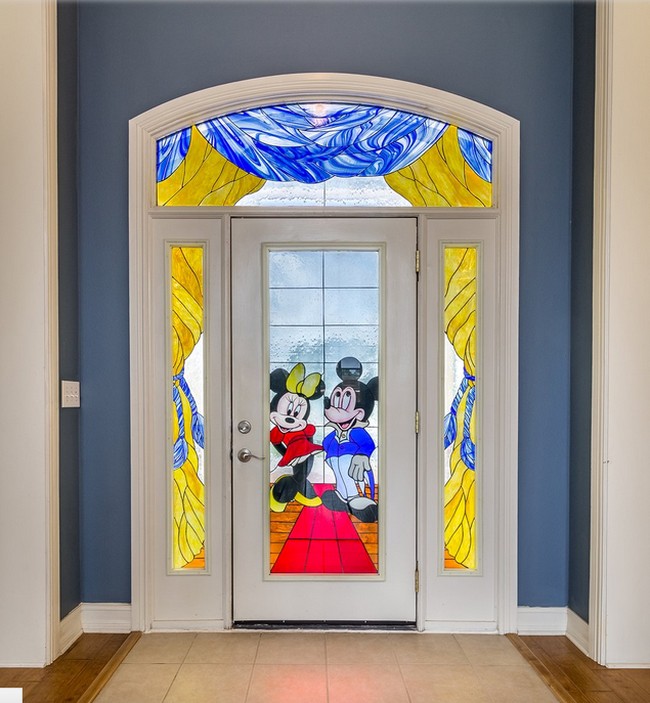 Pintu utama terbuat dari kaca yang dihiasi dengan gambar Mickey dan Minnie Mouse. Cantik, ya? Foto: Dok. People/Treasure Coast Sothebys International Realty