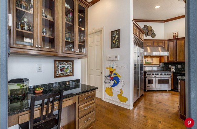 Ruang di antara tempat memasak dan meja bar pun dihiasi ornamen Disney. Ada Donald Duck yang tampak membawakan makanan. Cute! Foto: Dok. People/Treasure Coast Sothebys International Realty