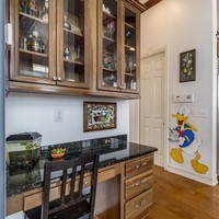 Ruang di antara tempat memasak dan meja bar pun dihiasi ornamen Disney. Ada Donald Duck yang tampak membawakan makanan. Cute! Foto: Dok. People/Treasure Coast Sothebys International Realty