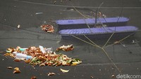 Sejumlah sampah platik dan daun kering nampak berserakkan di atas waring yang digunakan untuk mengurangi bau di Kali Item.