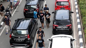 Pengendara yang ingin melalui jalur ini, hanya bisa lewat di jalur lambat. Sebab, di jalur sebelah kiri dipenuhi oleh driver yang memarkirkan kendaraannya untuk berdemo.