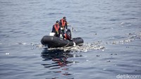 Petugas juga turun menggunakan perahu karet untuk menyisir puing-puing.