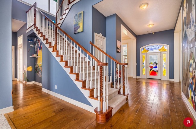 Selasar dekat pintu masuk menawarkan pemandangan interior yang lebih cantik lagi. Didominasi palet biru muda, rumah ini terlihat klasik tapi stylish di saat yang bersamaan, dengan mural Snow White dan 7 Kurcaci. Foto: Dok. People/Treasure Coast Sothebys International Realty