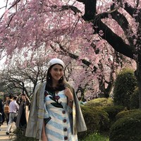 Nusara Suknamai berpose di bawah rindangnya pohon Sakura di Ueno Park, Tokyo, Jepang. Gaya busananya kekinian dengan dress bermotif embellishment floral dan blazer sebagai luaran. (Foto: Instagram/zara_nusara)