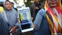 Sebagian dari mereka datang dengan membawa foto keluarga yang menaiki pesawat tersebut.